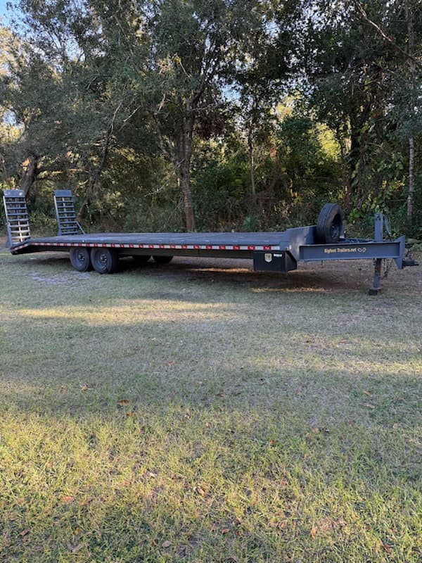 30ft flatbed trailer side view - 13300 lbs capacity deckover rental in Dover Florida